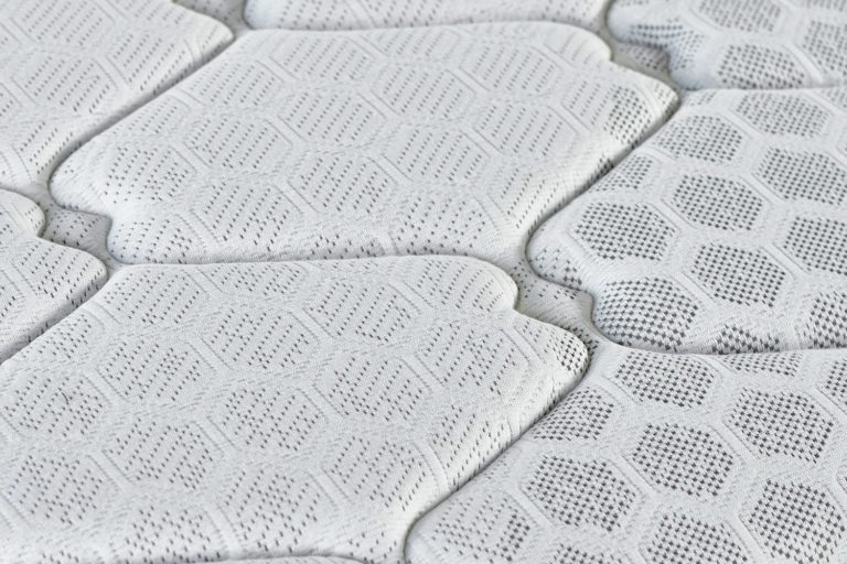 Close-up of a foam mattress with a quilted knitted cover