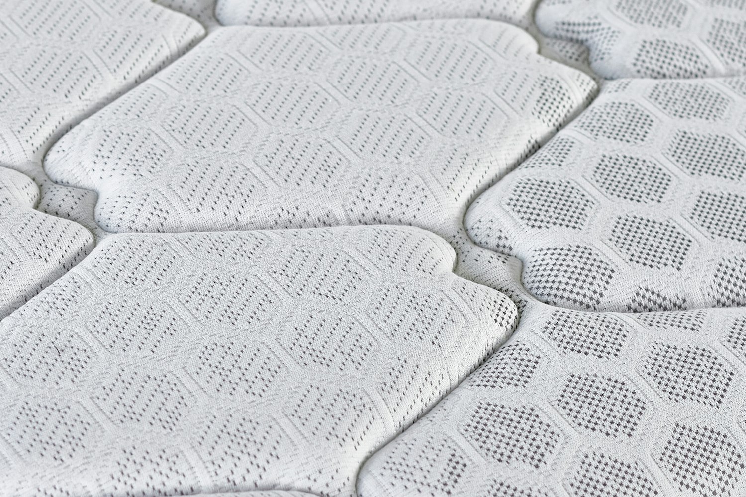 Close-up of a foam mattress with a quilted knitted cover