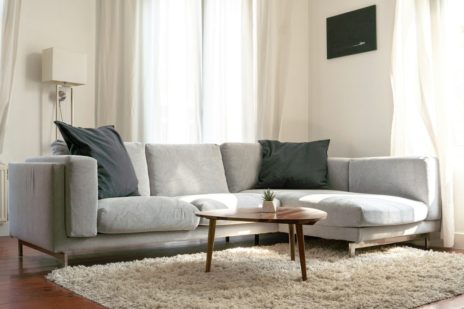 Grey upholstered sofa with plump seat and back cushions